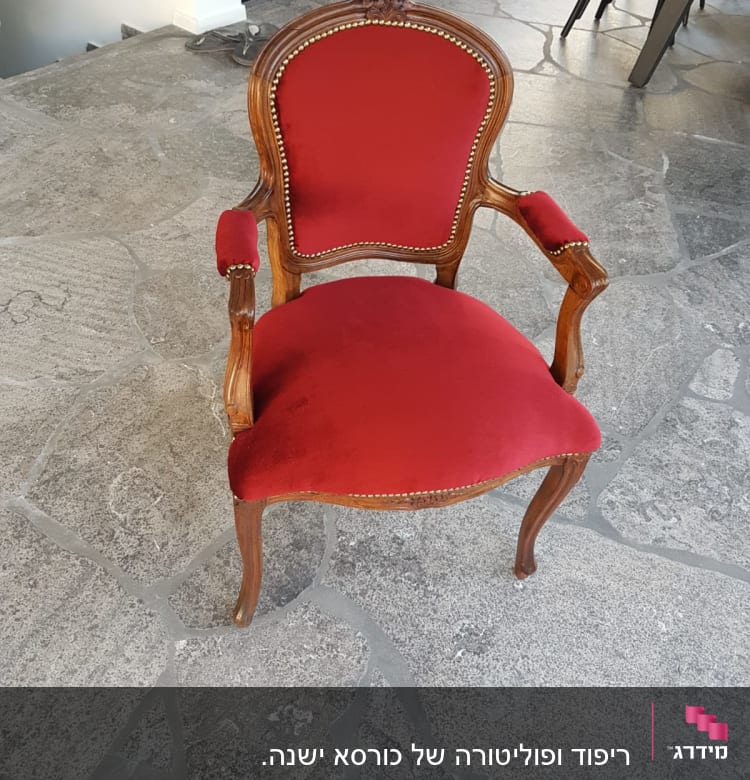 כיסא עץ מרופד בבד אדום עם מסמרים דקורטיביים